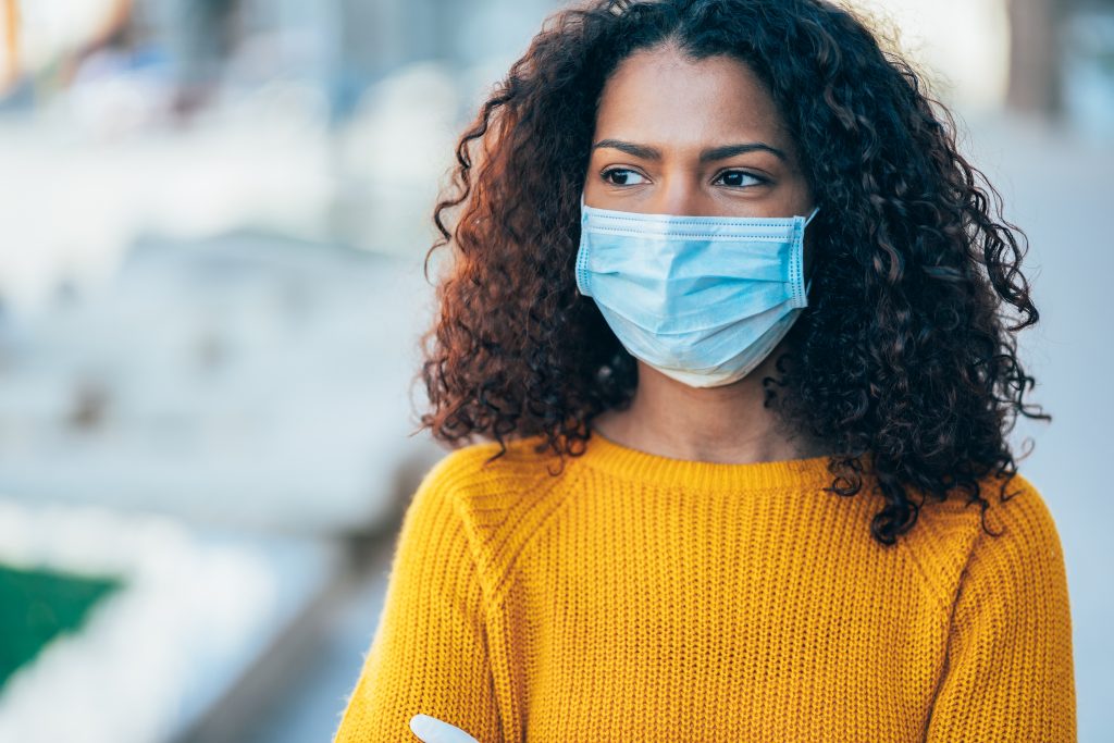 Portrait of young woman on the street wearing face protective mask to prevent Coronavirus
